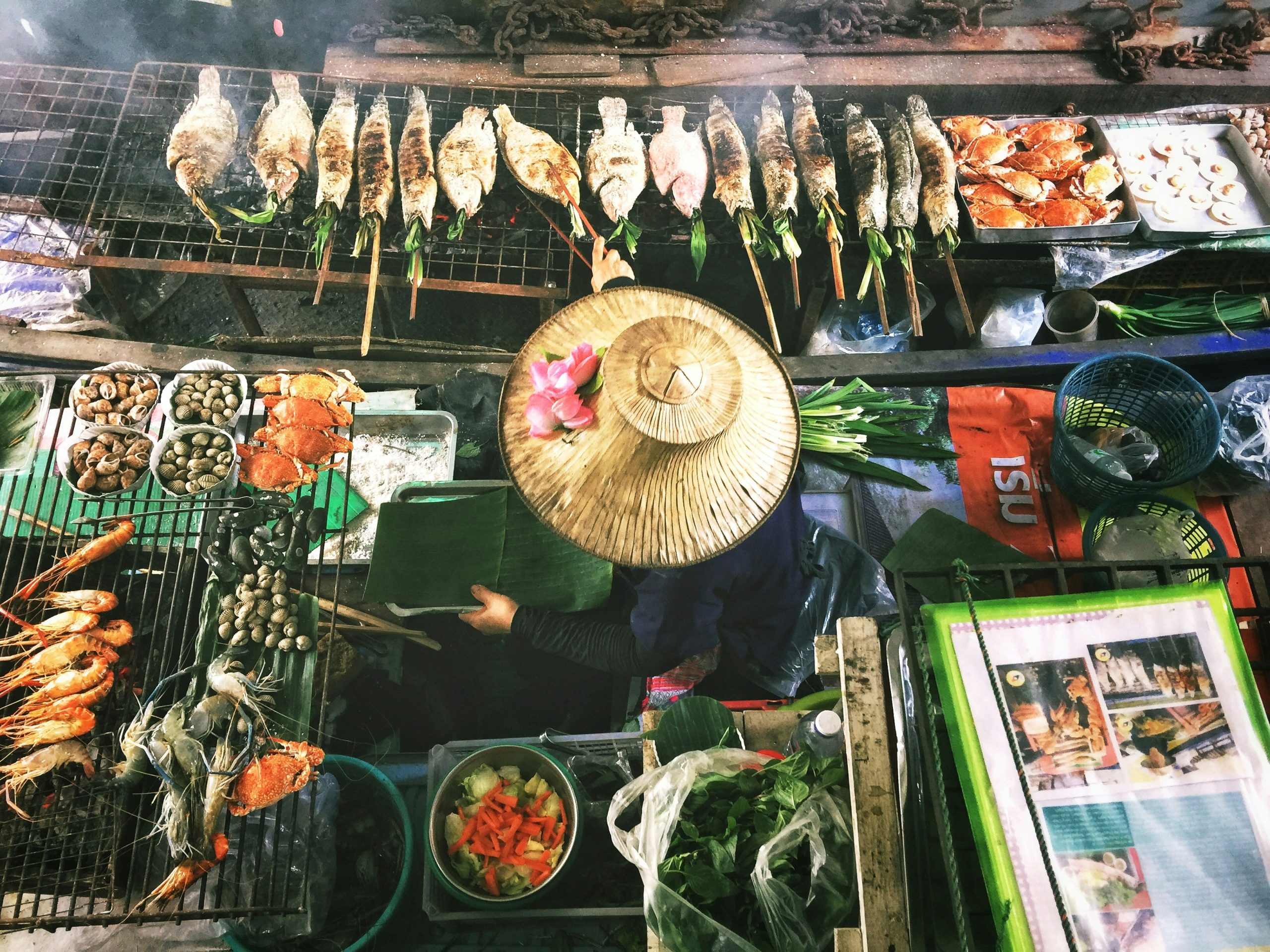 Woman grilling traditional Thai food at a local market