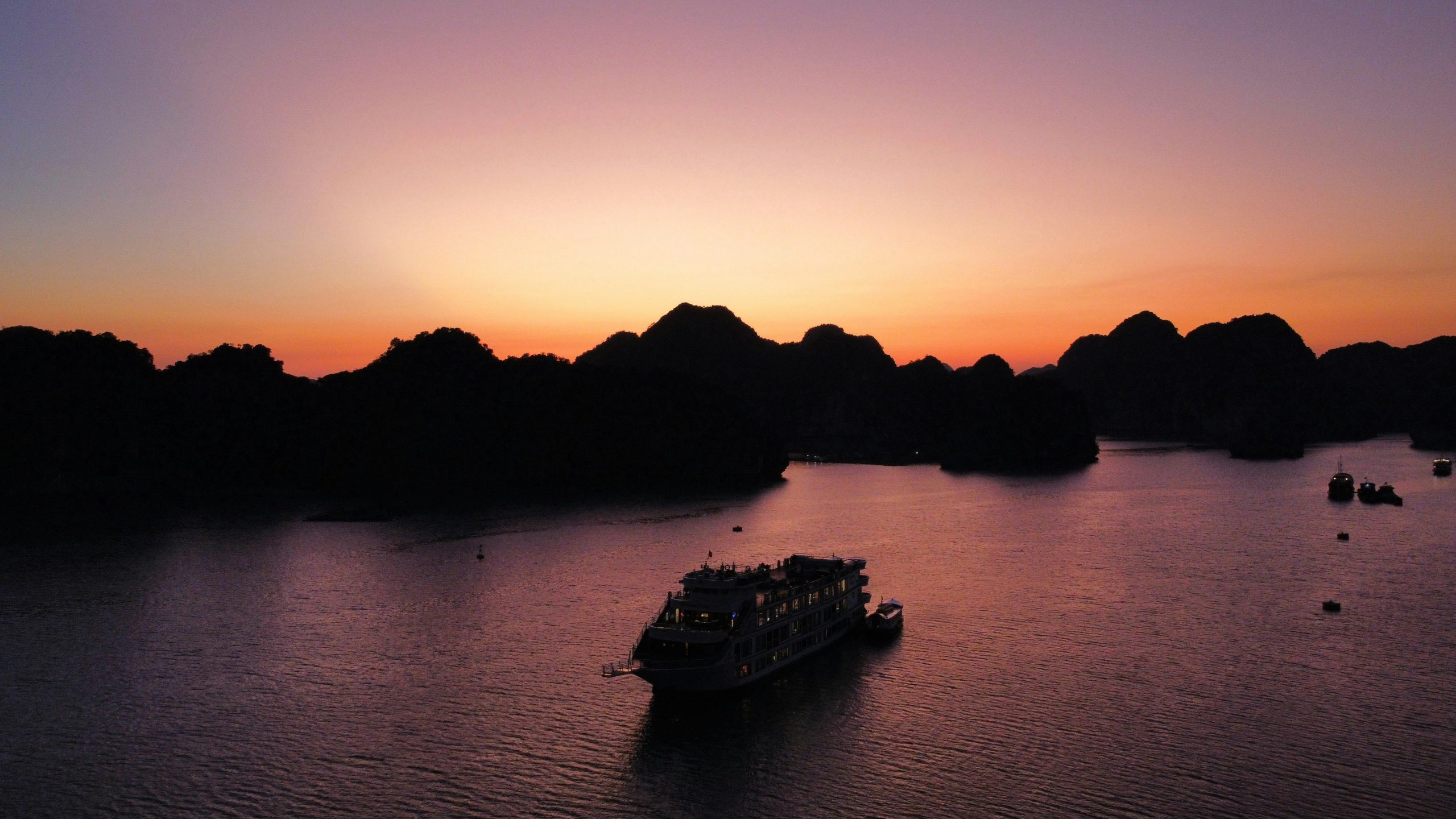 Sunset over limestone islands and emerald waters in Ha Long Bay, Vietnam