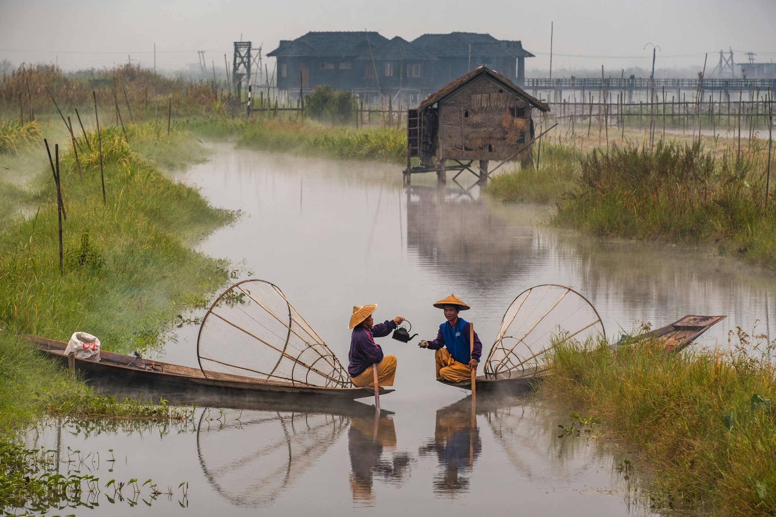 Local boat owners sharing tea on misty Inle Lake in Myanmar