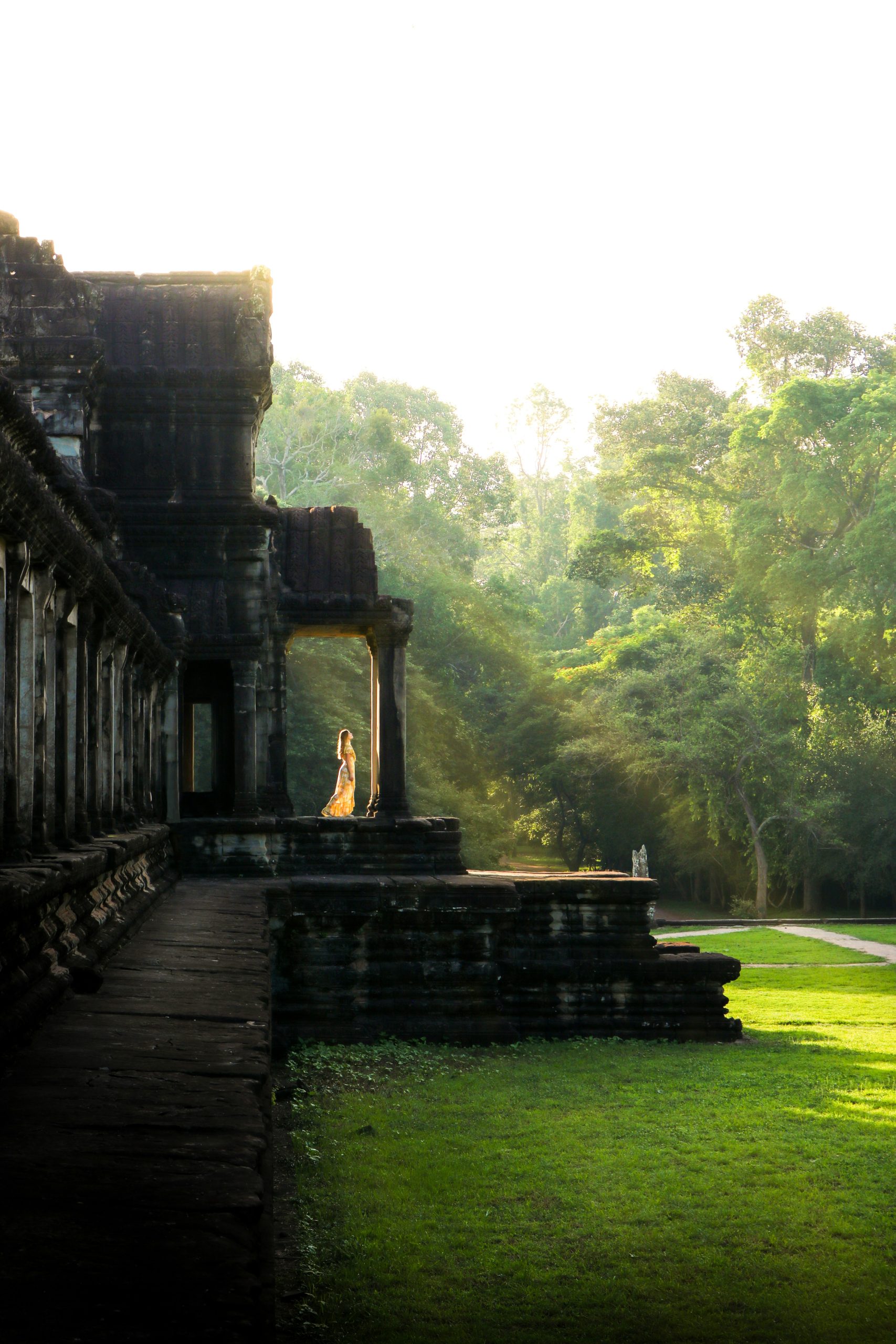 Traveler standing at the entrance of an ancient Khmer temple in Cambodia