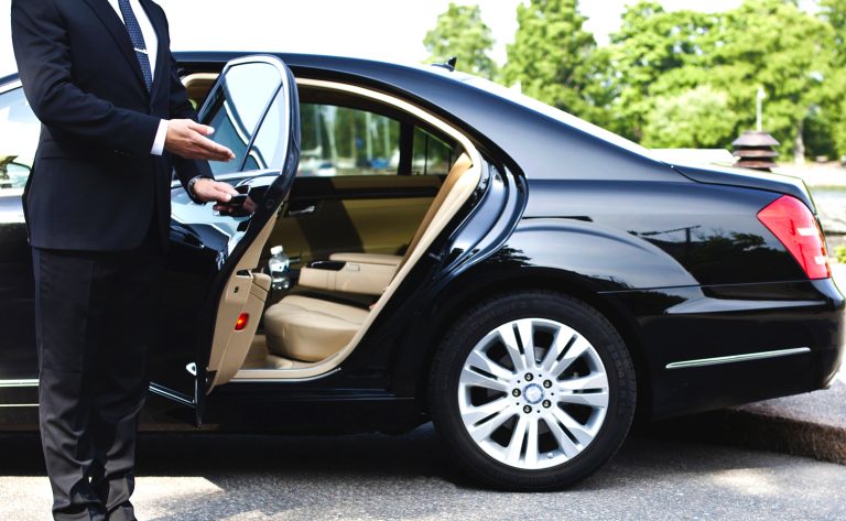 Traveller being welcomed at a car with the door held open