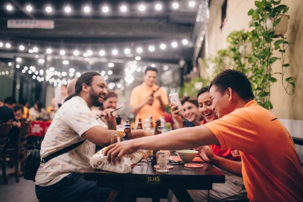 Travellers sharing dinner and laughing with their local guide