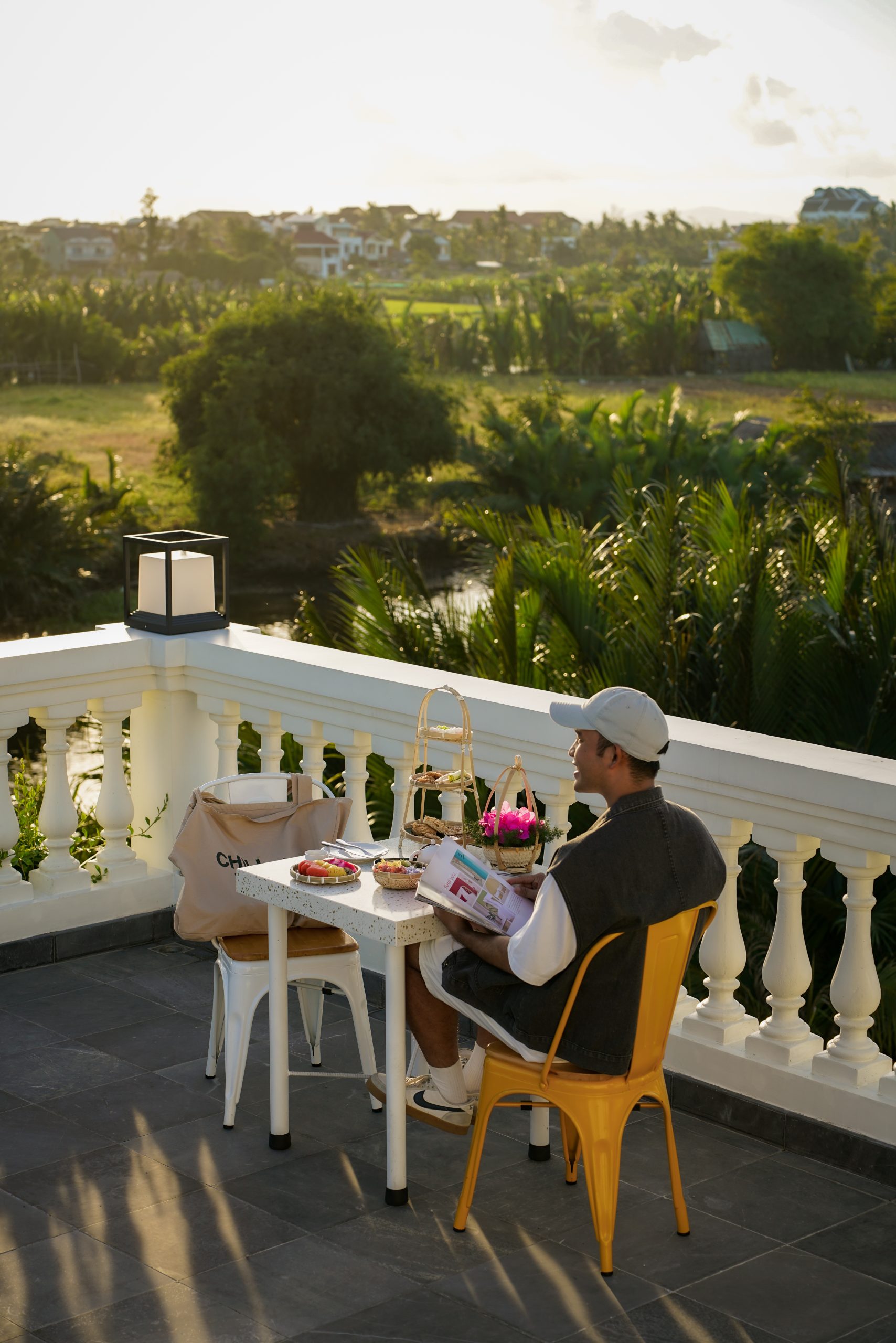 Guest enjoying afternoon tea on a hotel terrace surrounded by greenery